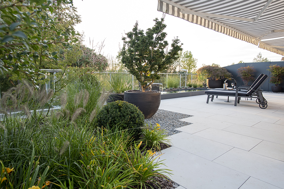 Terrasse mit Brunnen und grosszügiger Bepflanzung